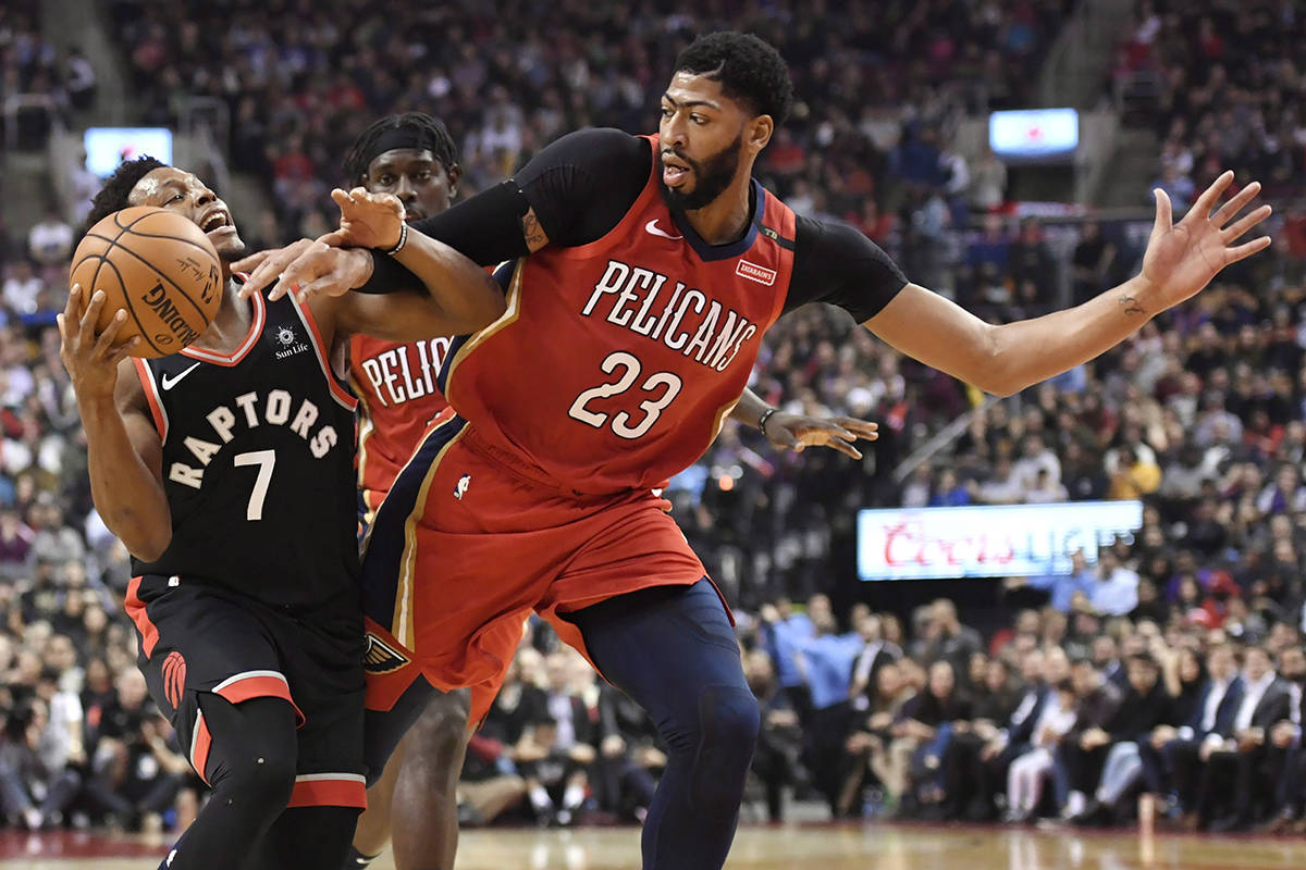 Toronto Raptors guard Kyle Lowry (7) and New Orleans Pelicans forward Anthony Davis (23) battle for the ball during first half NBA basketball action in Toronto on Monday, November 12, 2018. THE CANADIAN PRESS/Nathan Denette