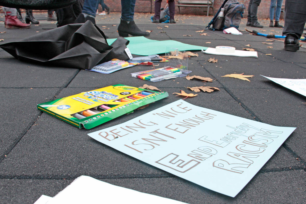 A poster reads “Being nice isn’t enough. End everyday racism” at a gathering in Victoria’s Centennial Square on Nov. 12. (Keili Bartlett/News staff)