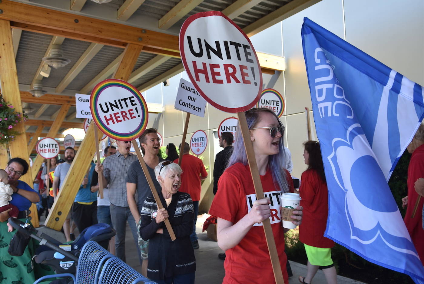 Food service workers at Victoria International Airport, represented by UNITE HERE Local 40, rally outside the arrivals gate in July. (Peninsula News Review file photo)