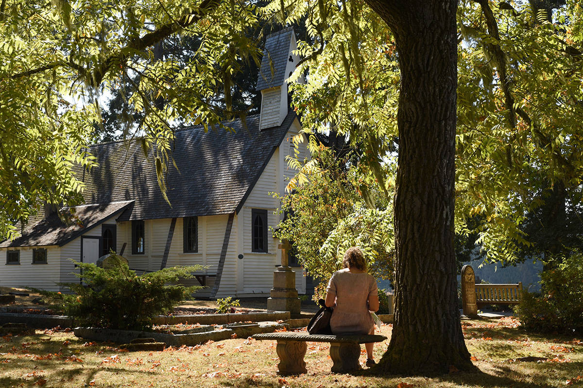 Andrea Pickard, Planner with Central Saanich, sits on a bench and enjoys the view of St. Stephen’s Anglican Church. Don Denton photography
