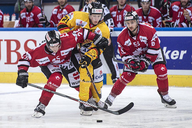 Team Canada forward Cory Emmerton (left) and teammate Maxim Noreau fend off a Kalpa Kuopio player during the final of the 2018 Spengler Cup. Canada dropped the game 2-1 after an eight-round shootout. Photo courtesy of @HC_Men/Twitter