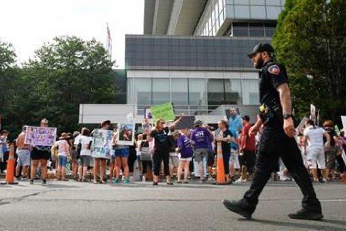 In this Aug. 17, 2018 file photo, family and friends who have lost loved ones to OxyContin and opioid overdoses protest outside Purdue Pharma headquarters in Stamford, Connecticut. (AP Photo/Jessica Hill, File)