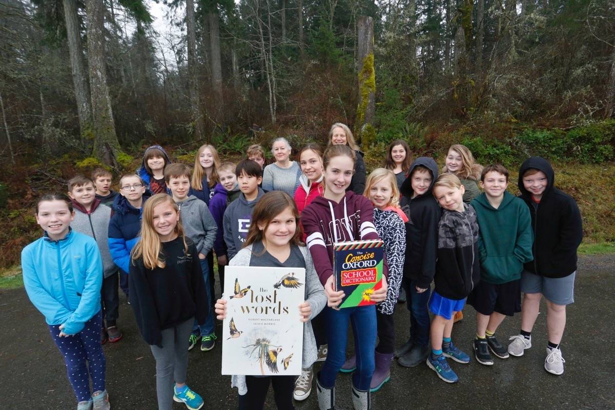 Qualicum Beach students Lauren Porter (front left) and Isabelle Gray (front right) show the book The Lost Words, alongside an Oxford dictionary with their Grade 5 Qualicum Beach Elementary School class. Many students in the class were inspired to send a letter to Oxford University Press over the nature words removed from their junior dictionary, which inspired The Lost Words book. — Adam Kveton Photo