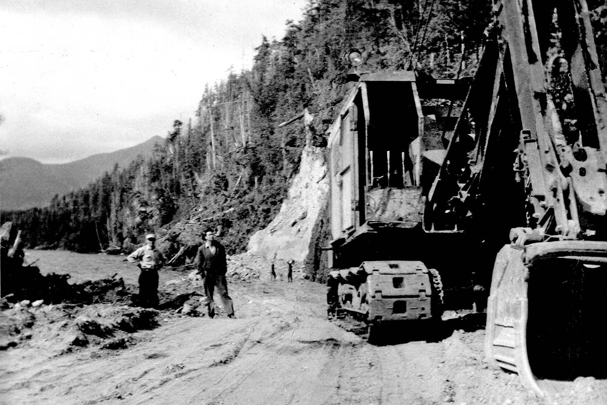 This photo from the 1950s is a reminder of earlier days. Frank Bull and Ron Matterson stand beside some heavy machinery in this view of work on the original road coming in and out of the West Coast. This is the same site of the present Kennedy Hill improvement project. (Photo submitted by Pieter Timmermans courtesy of the Ucluelet and Area Historical Society)