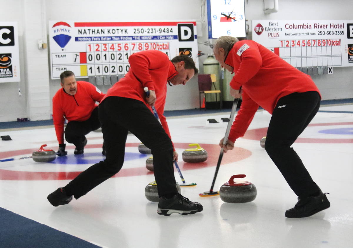 The front end of Craig Burton and Keith Clarke go hard on the brooms for teammate Steve Waatainen in the final end of the championship. JIM BAILEY photo