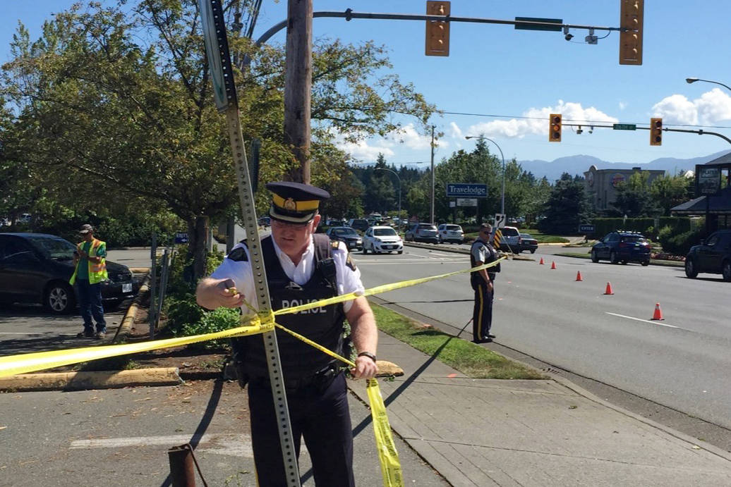 Former RCMP Inspect. Tim Walton ties police tape at the scene of a multi-vehicle collision at the intersection of Cliffe Avenue and 26th Street July 26, 2016. Black Press File Photo