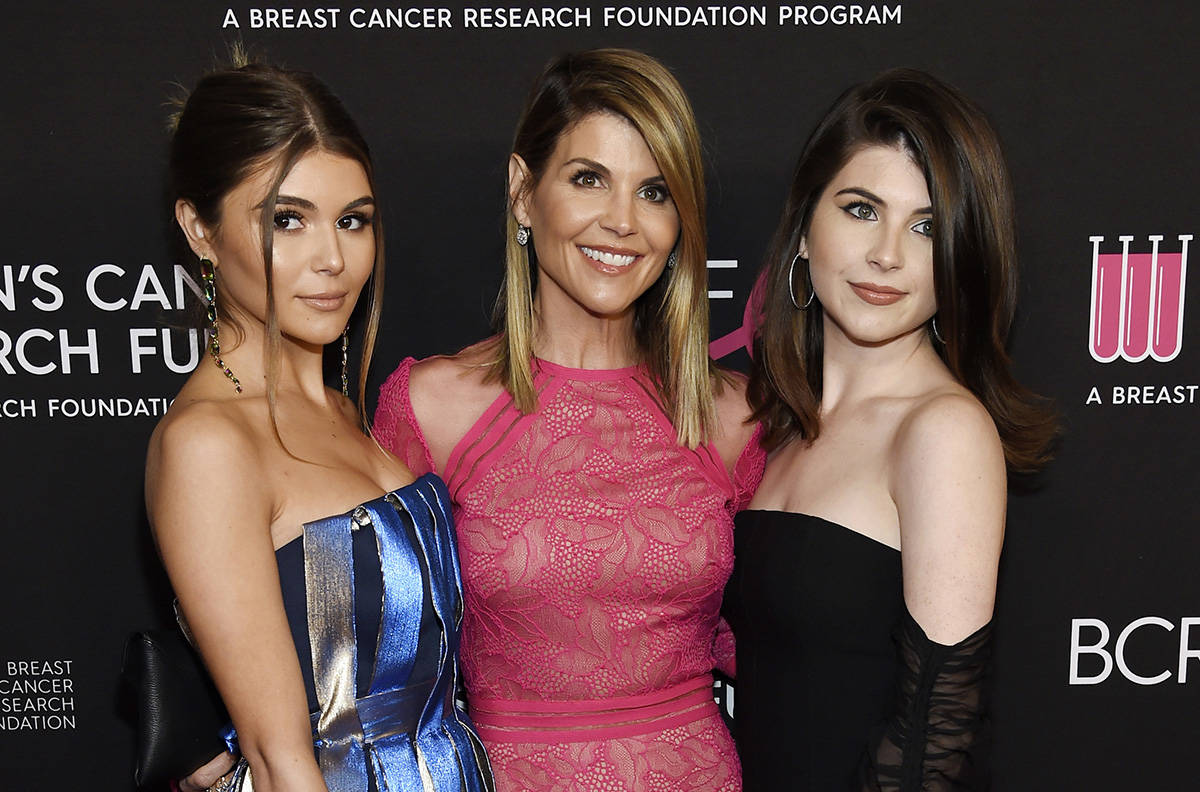 FILE - In this Feb. 28, 2019 file photo, actress Lori Loughlin, center, poses with daughters Olivia Jade Giannulli, left, and Isabella Rose Giannulli at the 2019 “An Unforgettable Evening” in Beverly Hills, Calif. Loughlin and her husband Mossimo Giannulli were charged along with nearly 50 other people Tuesday in a scheme in which wealthy parents bribed college coaches and other insiders to get their children into some of the most elite schools in the country, federal prosecutors said. (Photo by Chris Pizzello/Invision/AP, File)