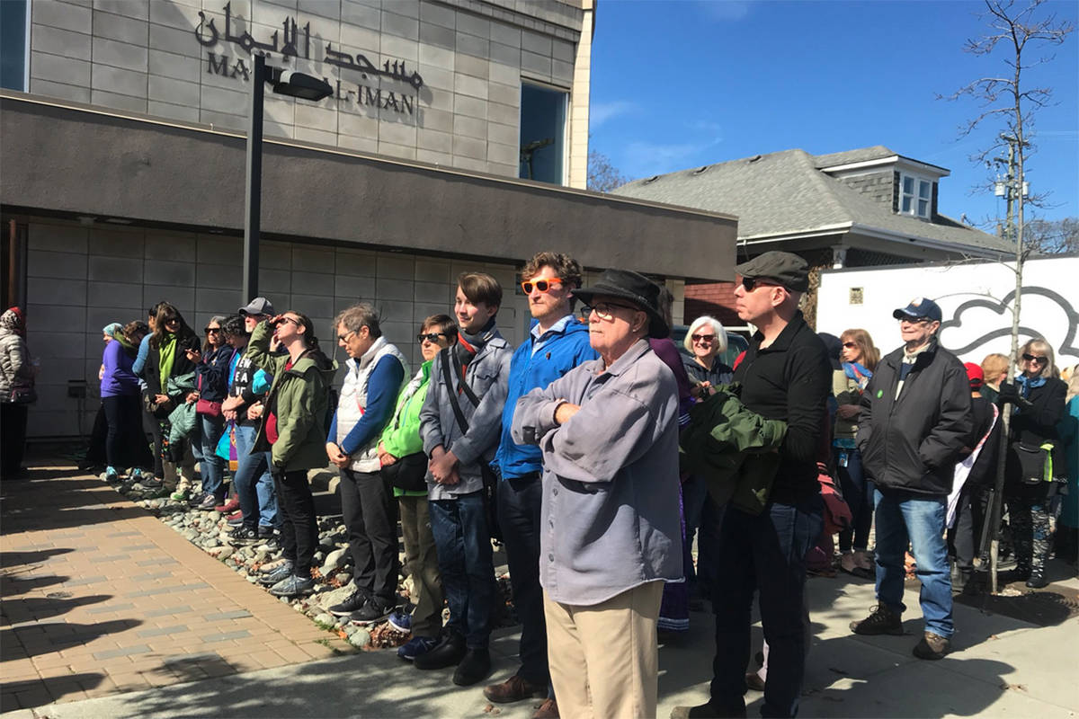 A human chain around Victoria’s Masjid Al-Iman mosque – a show of support for the Muslim community inside holding Friday prayer. (Keri Coles/News Staff)