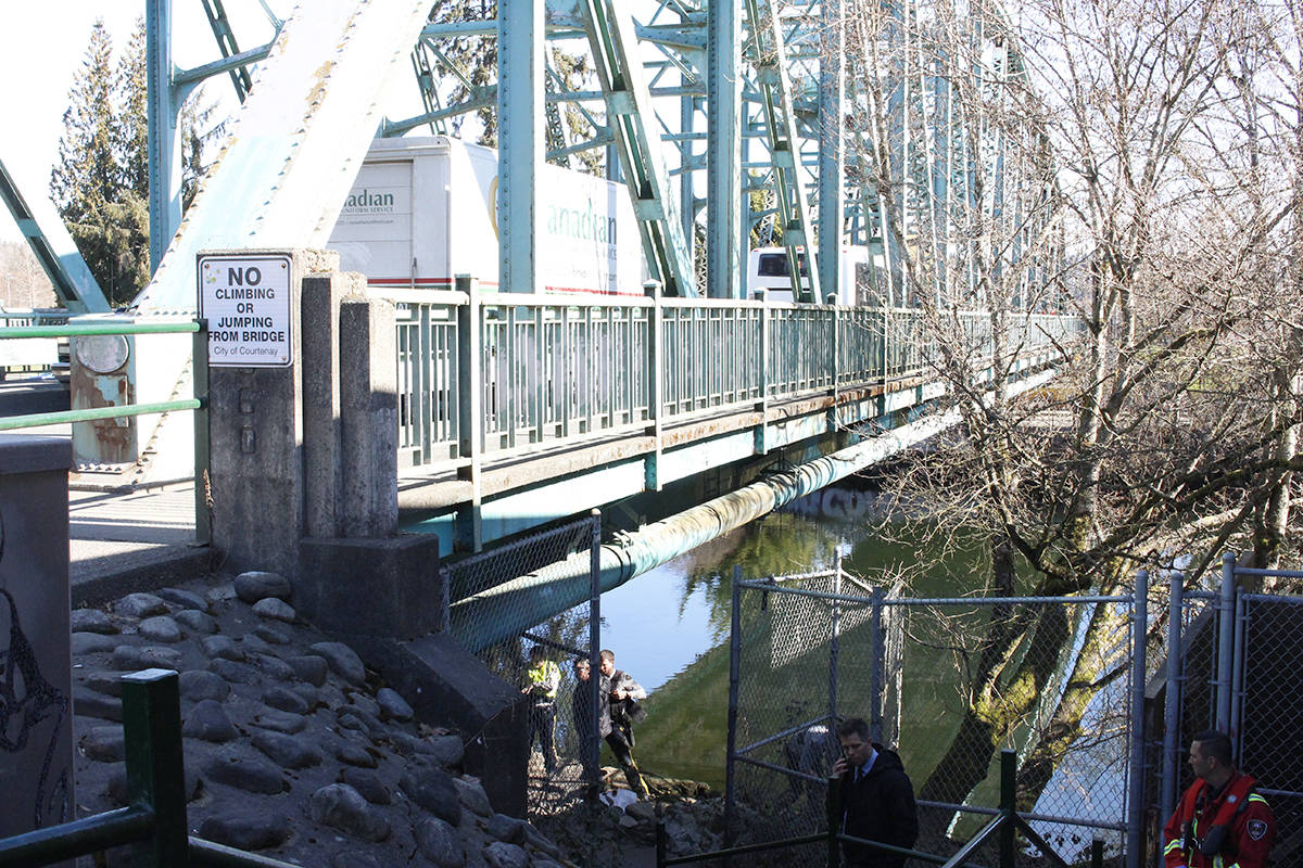 Emergency crews perform CPR on a man under the Fifth Street bridge in Courtenay Wednesday morning. Photo by Jolene Rudisuela