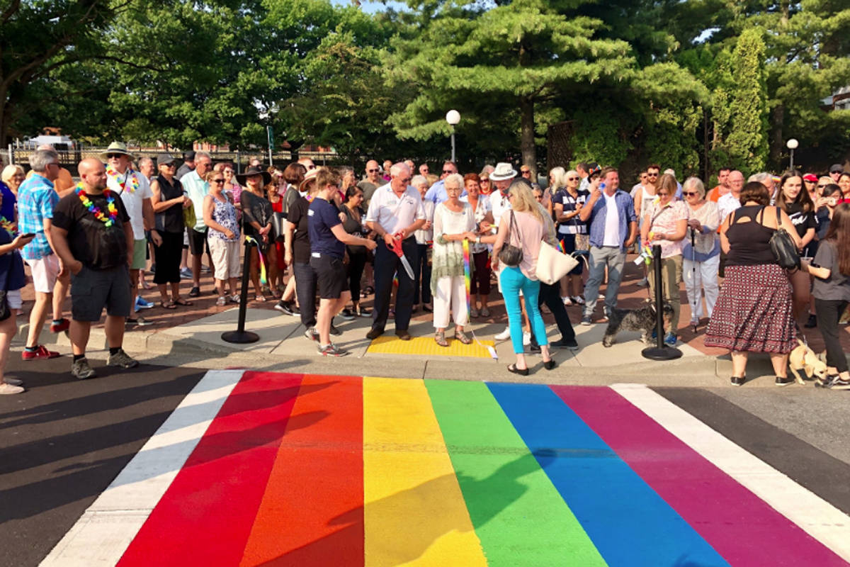 Former White Rock mayor Wayne Baldwin cuts a rainbow-coloured ribbon at the official unveiling of White Rock’s rainbow crosswalk in the Five Corners neighbourhood last year. (Bob Bezubiak/File photo)