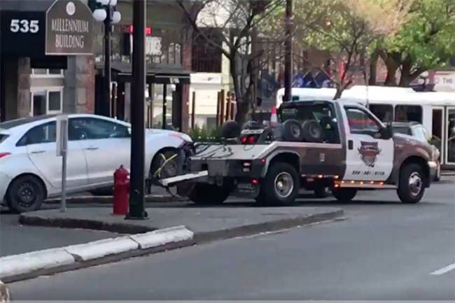 A vehicle is towed from the Yates Street parkade after a crash Tuesday. (Keri Coles/News Staff)