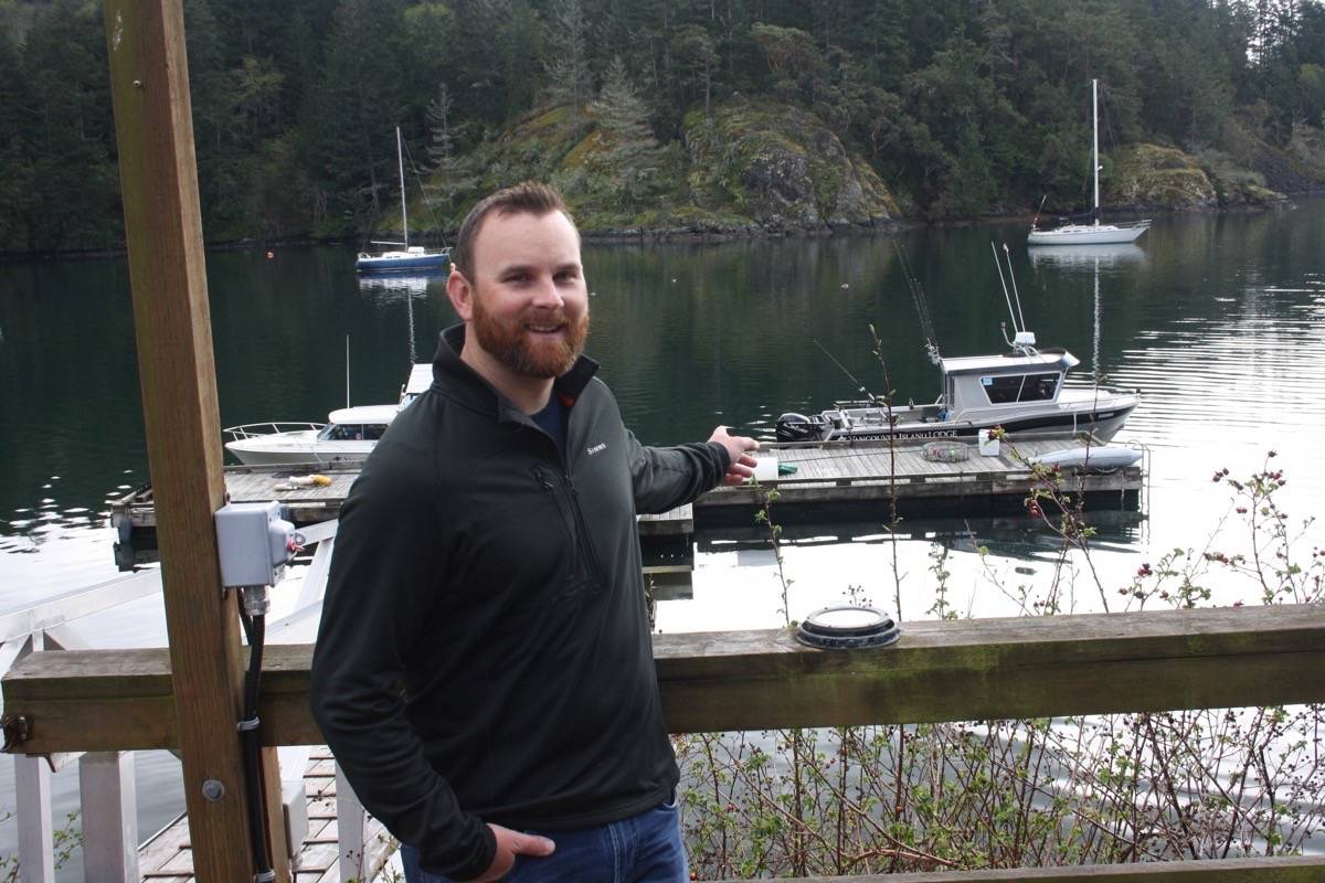 Ryan Chamberlain points out one of the boats used for his fishing charter business. (Tim Collins / Sooke News Mirror)