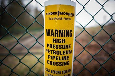 A sign warning of an underground petroleum pipeline is seen on a fence at Kinder Morgan’s facility where work is being conducted in preparation for the expansion of the Trans Mountain Pipeline, in Burnaby, B.C., on April 9, 2018. Kinder Morgan Canada Ltd. says it is continuing to evaluate its strategic options and hopes to announce its next steps in coming weeks. The company was spun off from its American parent in mid-2017 to raise money to build the Trans Mountain pipeline expansion but that purpose no longer exists after it sold the existing pipeline and its expansion project to the federal government for $4.5 billion last summer. THE CANADIAN PRESS/Darryl Dyck