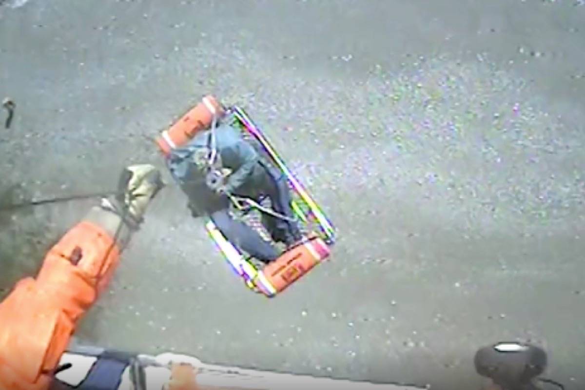 An MH-65 Dolphin helicopter crew from Coast Guard Sector Field Office Port Angeles, Wash., hoists two boaters who had to abandon ship and swim to the shore on Sunday, April 28, 2019. (U.S. Coast Guard District)