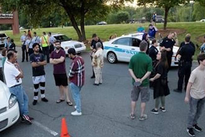 People gather across from the campus of UNC Charlotte after a shooting incident at the school Tuesday, April 30, 2019, in Charlotte, N.C. (AP Photo/Jason E. Miczek)