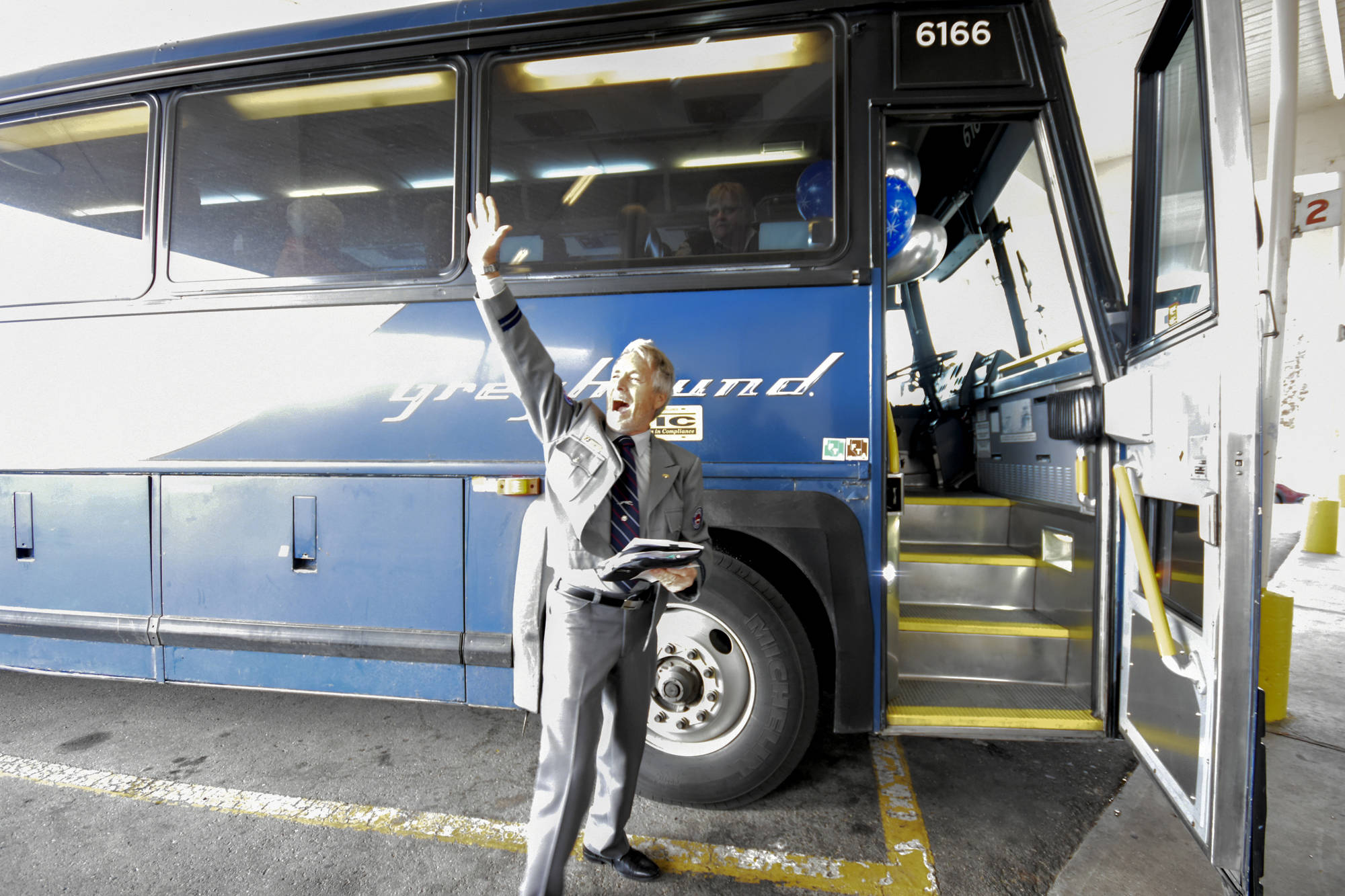 Veteran Greyhound bus driver Blake Moore gives a shout out to those who gathered to wish him well on his final route Wednesday. Mark Brett/Western News