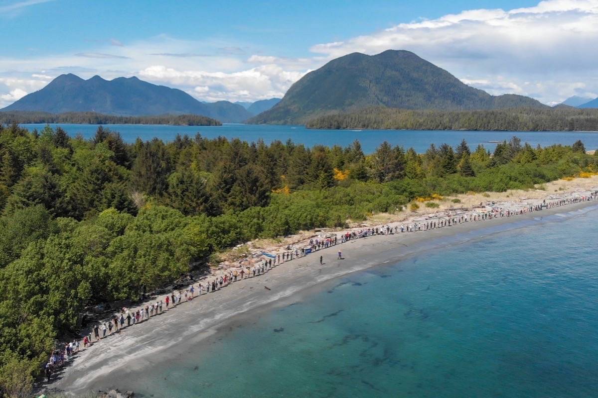 Hands Across the Sand participants lock hands and spread out across the shore of Clayoquot Island on May 19. The international movement is a 15-minute peaceful gathering to promote clean energy and ending fossil fuel investments. (Photo: Arya Touserkani / Surfrider Pacific Rim Volunteer)