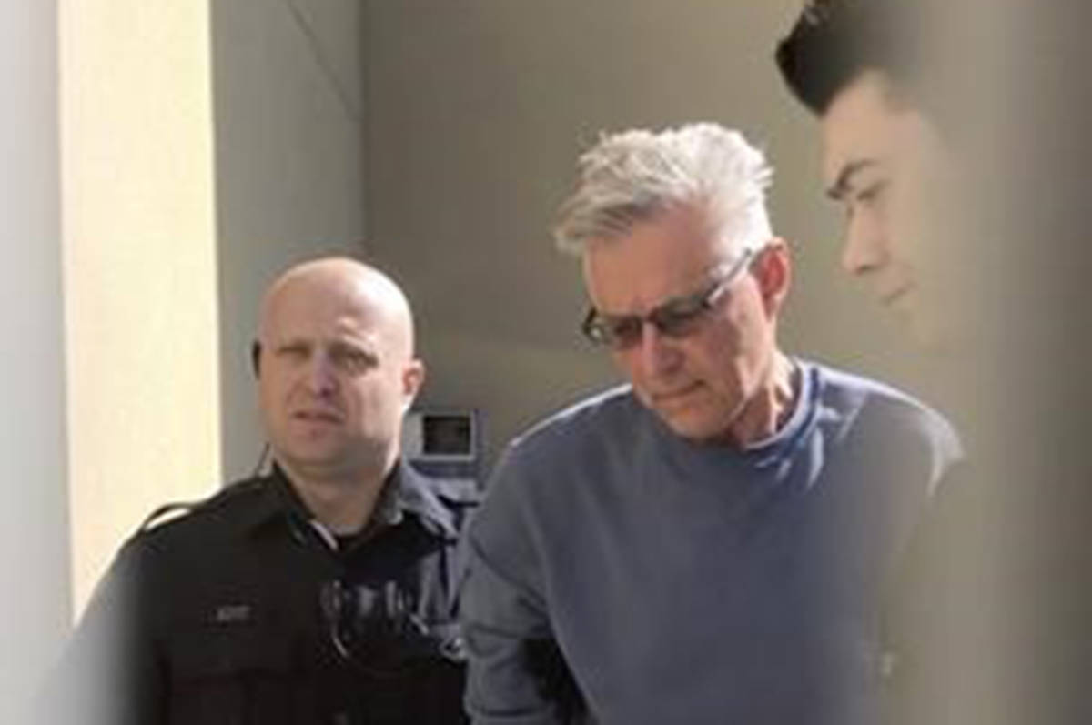 John Brittain is escorted from the RCMP detachment in Penticton, B.C., on Tuesday, April 16, 2019, in this image made from video. THE CANADIAN PRESS/Amy Smart