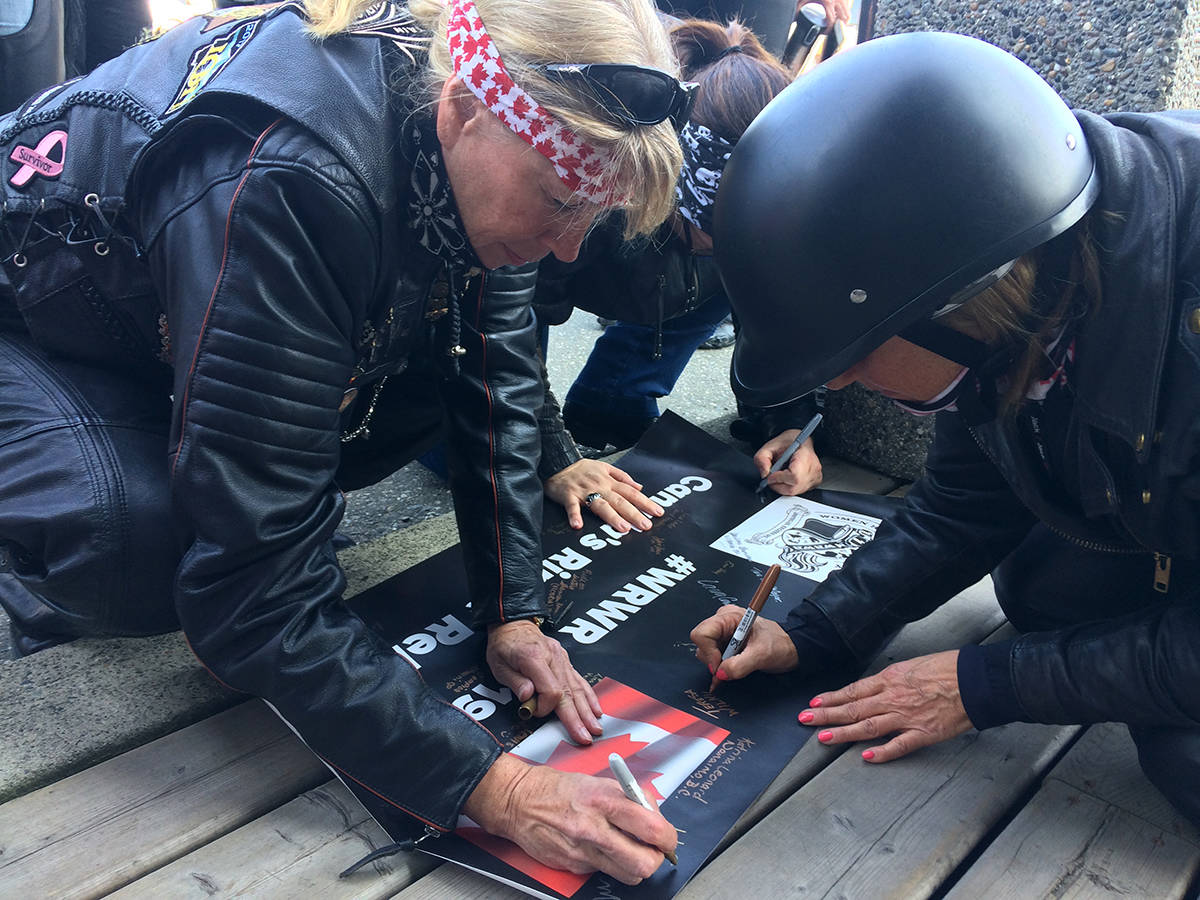 Women riders sign a banner for a leg of a Ripple Rally from Victoria to Balfour. They stopped in Chilliwack on May 31 for a leg to Kelowna. (Jessica Peters/ The Progress)