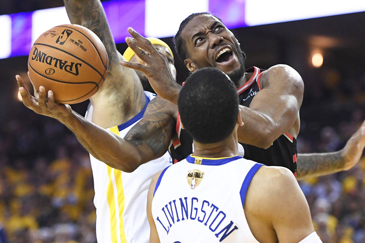 Toronto Raptors forward Kawhi Leonard (2) jumps for the basket as Golden State Warriors centre DeMarcus Cousins (0) and Golden State Warriors guard Shaun Livingston (34) defend during second half basketball action in Game 3 of the NBA Finals in Oakland, California on Wednesday, June 5, 2019. THE CANADIAN PRESS/Frank Gunn