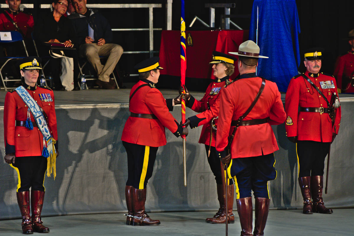 RCMP Commissioner Brenda Lucki hands the divisional ensign to Deputy Commissioner Jennifer Strachan, symbolically handing over the reins of the RCMP’s E division from Brenda Butterworth-Carr (left). (Photo: Nick Laba)