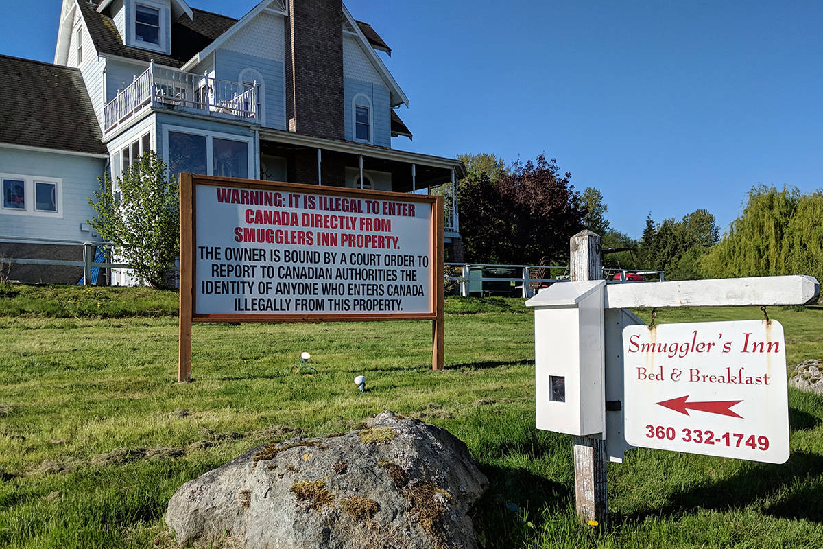 A sign erected at the Smuggler’s Inn reads: “Warning: It is illegal to enter Canada directly from Smugglers Inn Property. The owner is bound by a court order to report to Canadian authorities the identity of anyone who enters Canada illegally from this property.” (File photo)