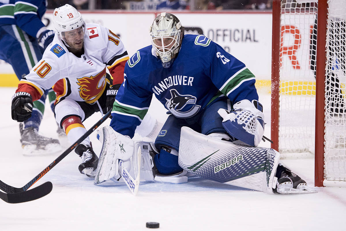 Calgary Flames center Derek Ryan (10) tries to get a shot past Vancouver Canucks goaltender Jacob Markstrom (25) during first period NHL action at Rogers Arena in Vancouver, Wednesday, Oct, 3, 2018. THE CANADIAN PRESS/Jonathan Hayward