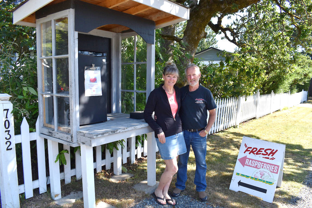 Leeanne and Jack Guthrie at the fruit stand outside their Brentwood Bay home. The stand typically sells baskets of raspberries for $5. (Nick Murray/News Staff)