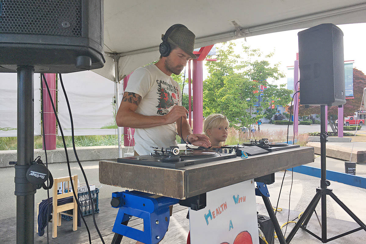 Tod Dugas, also known as DJ Saskatoon Tod, is shown with one of his daughters at an all-ages dance in Spirit Square on Saturday. Photo by David Gordon Koch/Campbell River Mirror