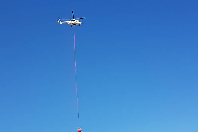 A helicopter bucketing water at the Richter Mountain wildfire on Sunday. (BC Wildfire photo)