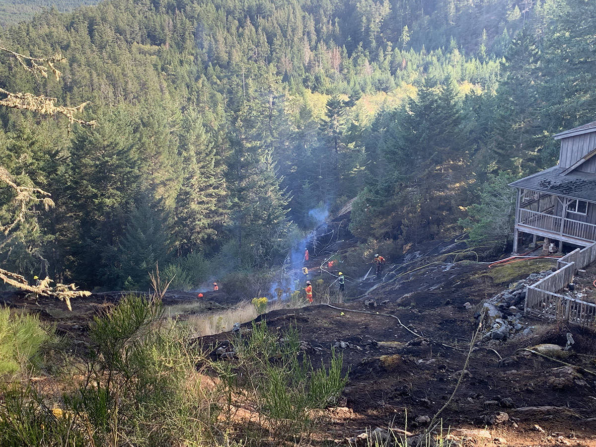 Firefighters work to contain a brush fire that broke out in East Sooke on Aug. 8. (Submitted photo)