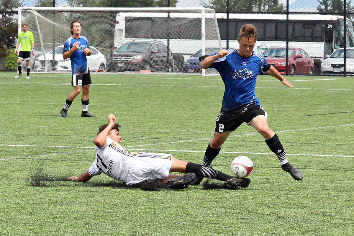 Peninsula Pirates player Chris (Bambi) Dominguez and VIU Mariners opponent Diego Corlazzoli vie for a ball during Sunday’s pre-season game at Merle Logan Field. (GREG SAKAKI/The News Bulletin)