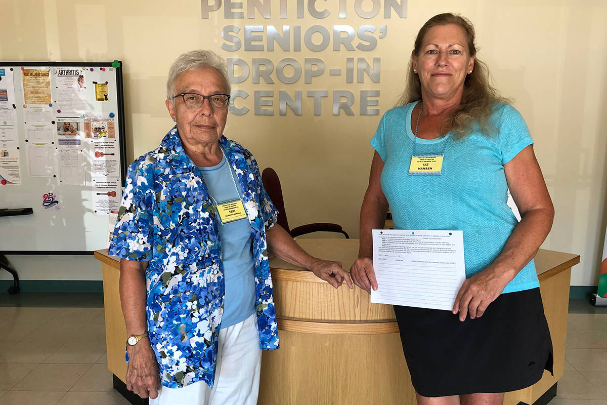 Retired nurse Teri McGrath and Liz Hansen from the Penticton Seniors’ Centre hold up the petition they will be sending out to seniors’ centre across B.C. this week. (Robin Grant-Western News Staff)