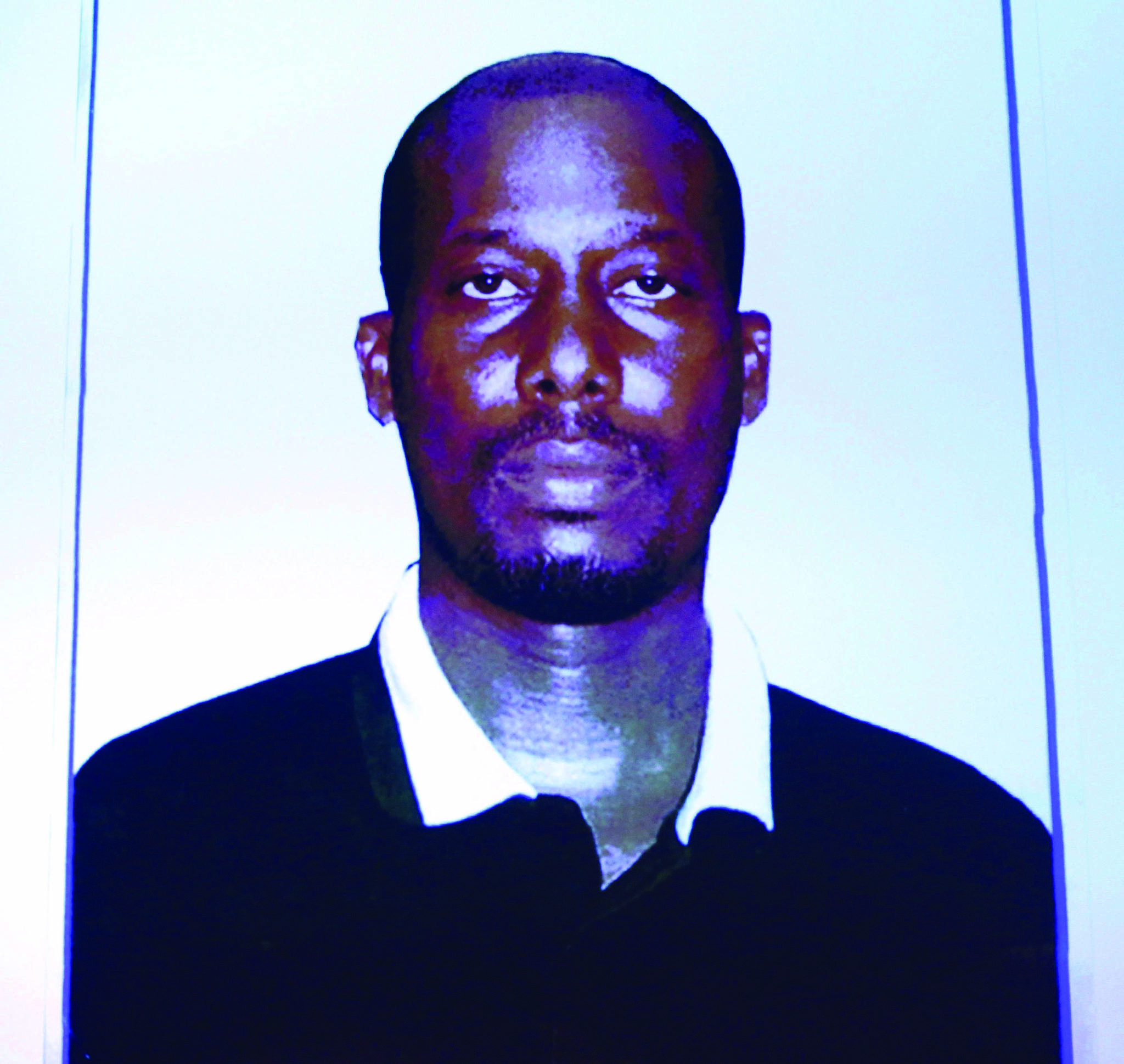 An image of Ali Omar Ader is projected on a screen at RCMP headquarters during a press conference in Ottawa about his arrest for the kidnapping of Canadian journalist Amanda Lindhout, on June 12, 2015. A Somalian man found guilty in the kidnapping of Amanda Lindhout has been sentenced to 15 years in prison. Ontario Superior Court Justice Robert Smith handed down the sentence for Ali Omar Ader today. THE CANADIAN PRESS/ Patrick Doyle