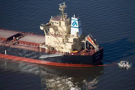 A spill response boat monitors a boom placed around the bulk carrier cargo ship Marathassa after a bunker fuel spill on Burrard Inlet in Vancouver on Thursday April 9, 2015. (Darryl Dyck/The Canadian Press)
