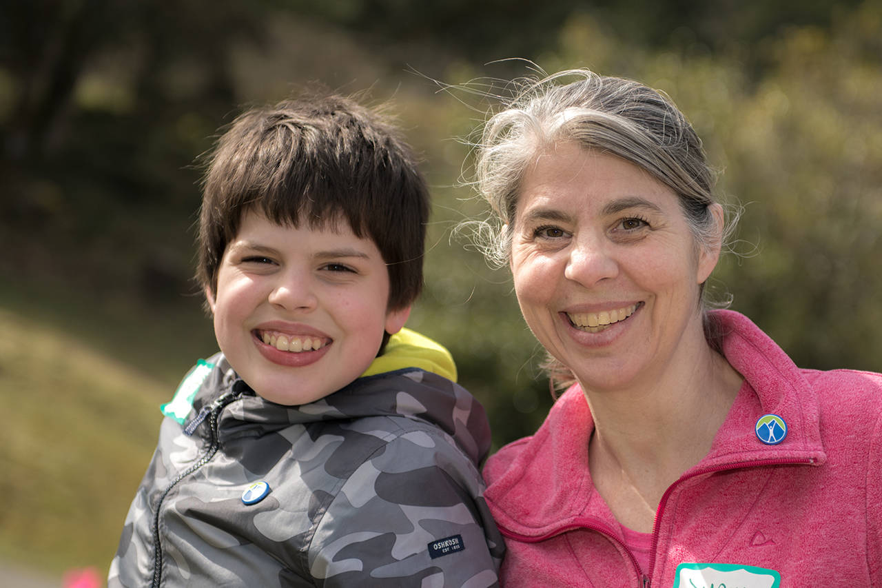 D’Arcy Mahoney (right) and her son Nathan are big fans of Power to Be’s Adaptive Recreation Program (File contributed/Power to Be) [Alt text: A 12-year-old boy dressed in grey and his mother, dressed in pink, smile at the camera with greenery in the background.]
