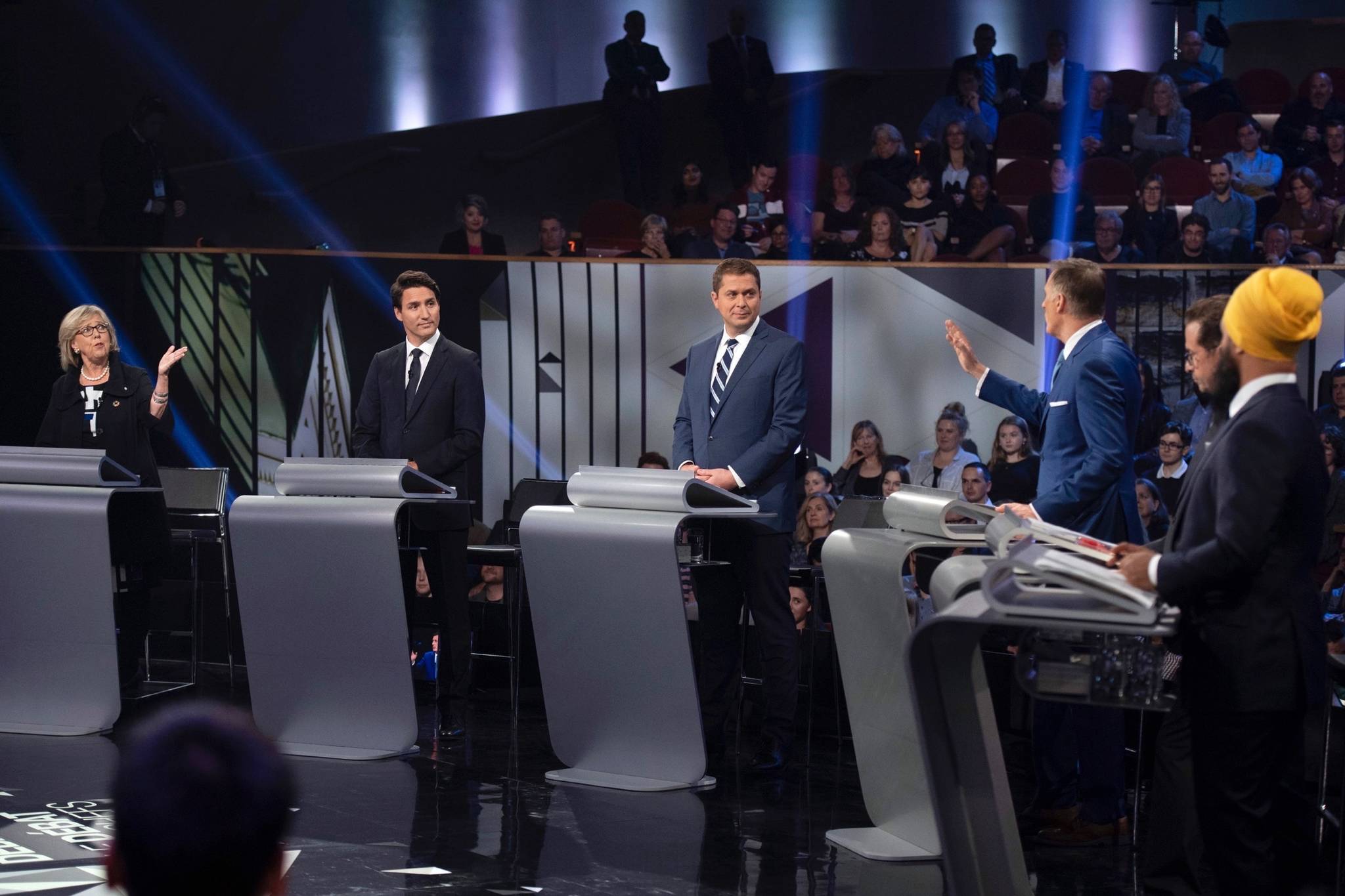 Green Party leader Elizabeth May, left, and People’s Party of Canada leader Maxime Bernier, third from right, exchange ideas as Liberal leader Justin Trudeau, Conservative leader Andrew Scheer, Bloc Quebecois leader Yves-Francois Blanchet and NDP leader Jagmeet Singh look on during the Federal leaders debate in Gatineau, Que. on Monday, October 7, 2019. THE CANADIAN PRESS/Justin Tang