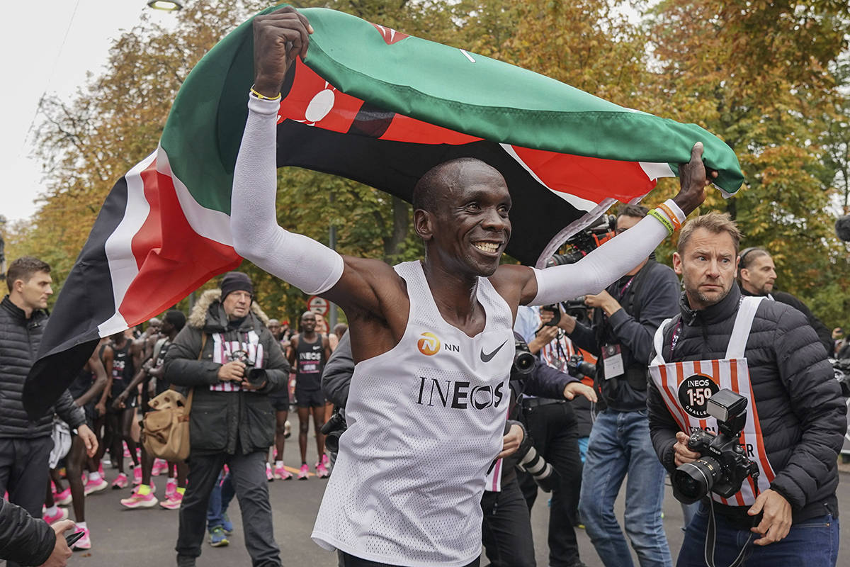 Eliud Kipchoge celebrates with the Kenyan flag after breaking the historic two hour barrier for a marathon in Vienna, Saturday, Oct. 12, 2019. Eliud Kipchoge has become the first athlete to run a marathon in less than two hours, although it will not count as a world record. The Olympic champion and world record holder from Kenya clocked 1 hour, 59 minutes and 40 seconds Saturday at the INEOS 1:59 Challenge, an event set up for the attempt. (Jed Leicester/The INEOS 1:59 Challenge via AP)