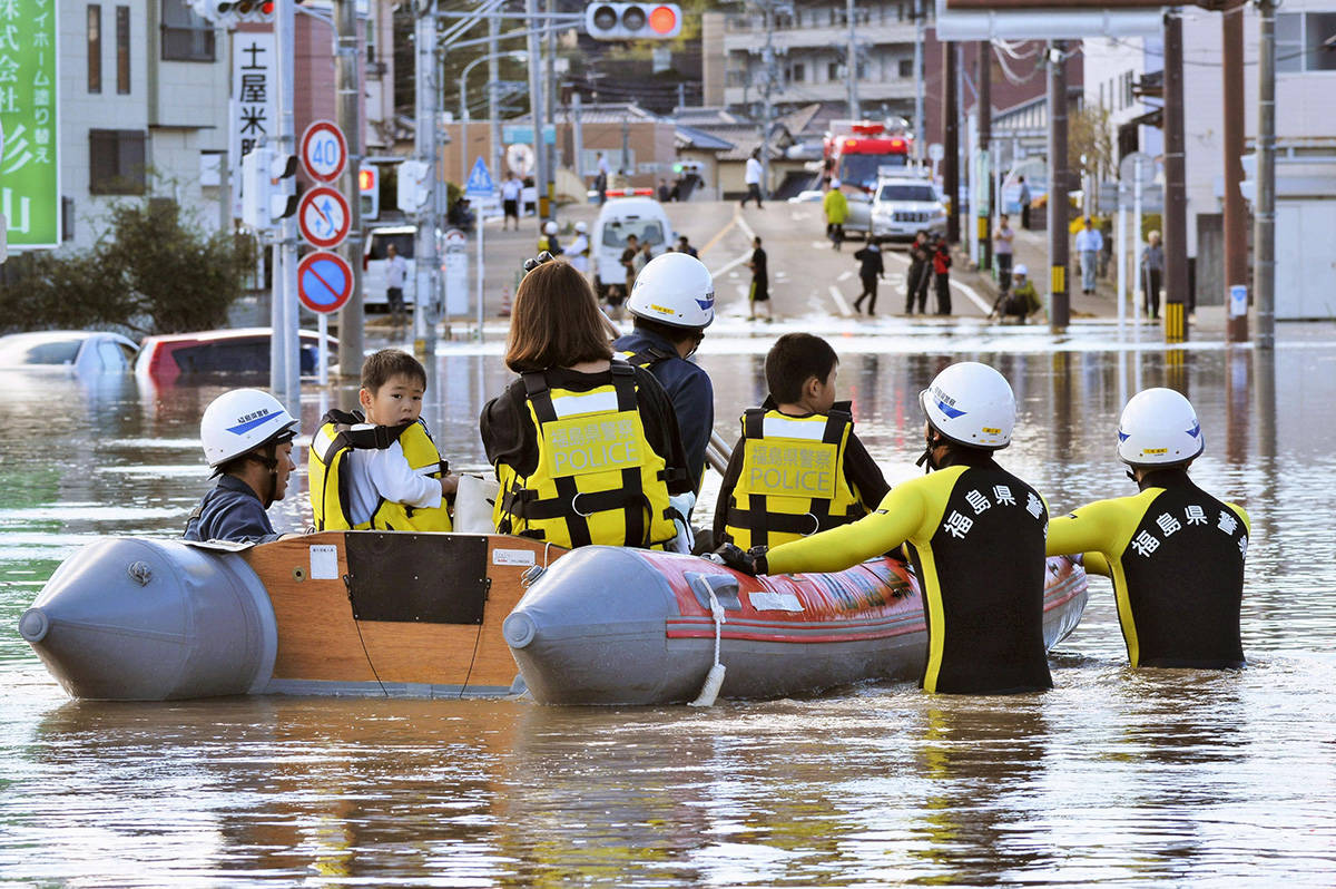 Residents on a rubber boat are rescued as they were stranded by Typhoon Hagibis, in Iwaki, Fukushima prefecture, northern Japan, Sunday, Oct. 13, 2019. Rescue efforts for people stranded in flooded areas are in full force after a powerful typhoon dashed heavy rainfall and winds through a widespread area of Japan, including Tokyo.(Kyodo News via AP)