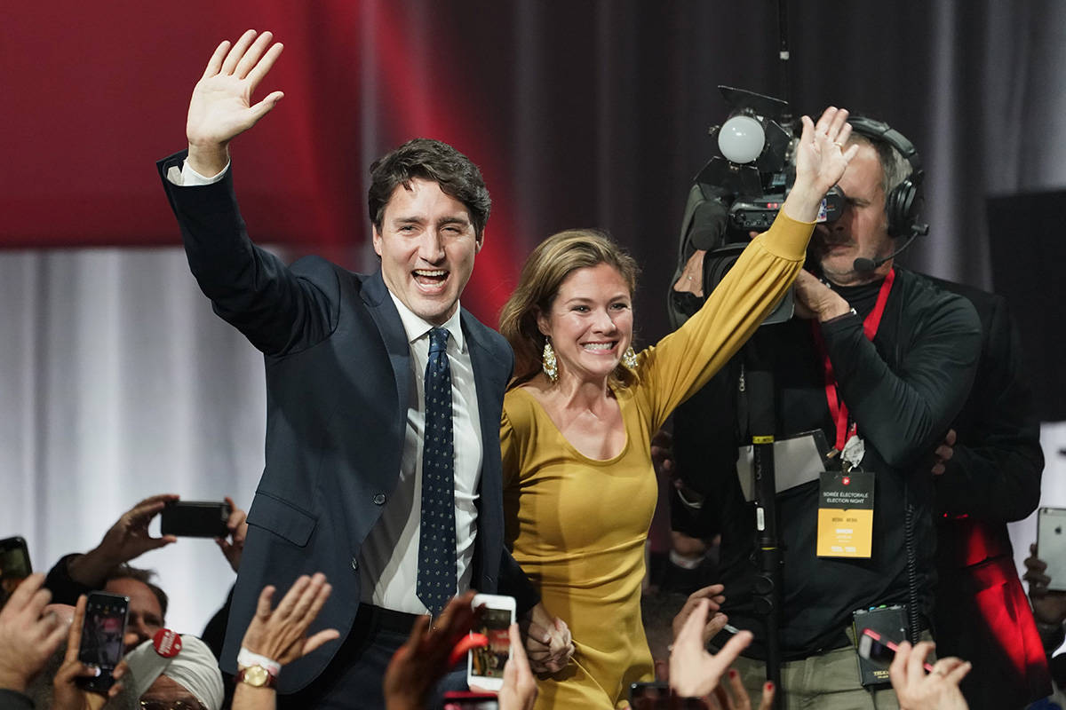 Liberal leader Justin Trudeau and wife Sophie Gregoire Trudeau, in a dress by Eliza Faulkner, wave as they go on stage at Liberal election headquarters in Montreal, Monday, Oct. 21, 2019. THE CANADIAN PRESS/Paul Chiasson