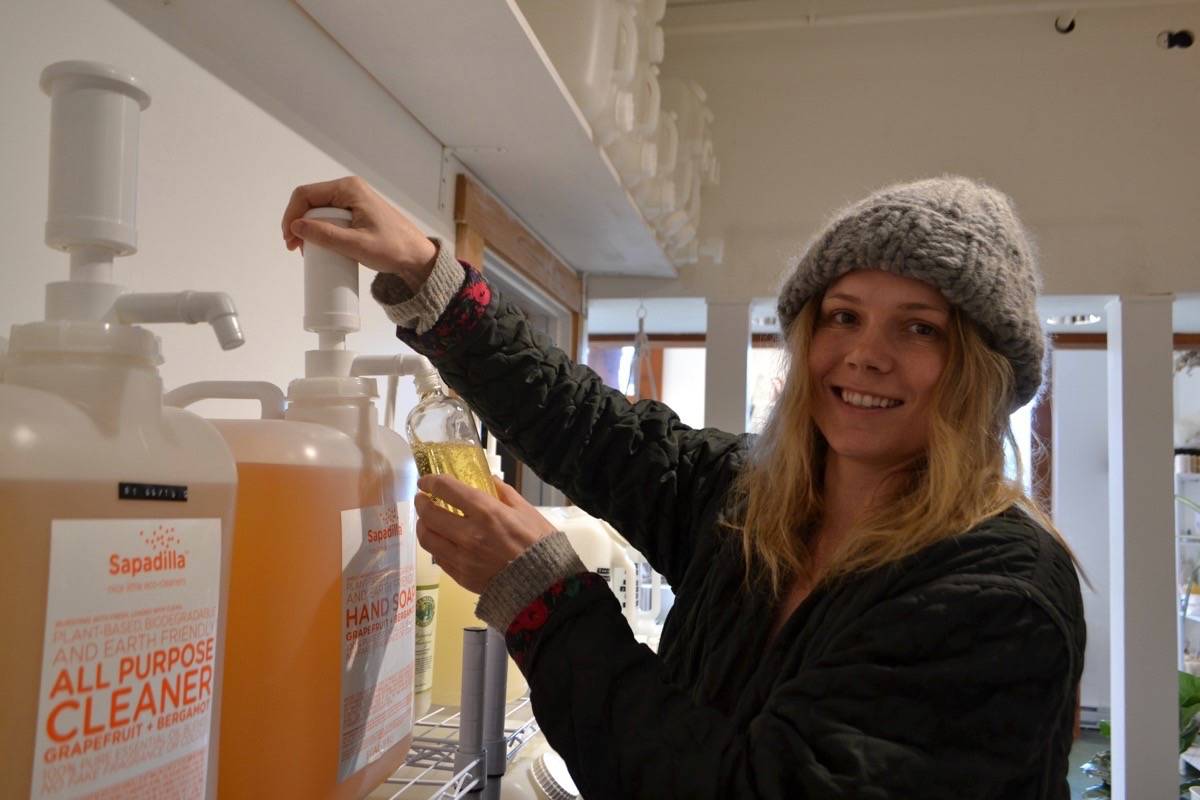 Diane Rudge refills a hand soap container at The Den quality goods and refillery in Ucluelet. The store stocks products that are ocean-friendly, biodegradable and local. (Nora O’Malley / Westerly News)