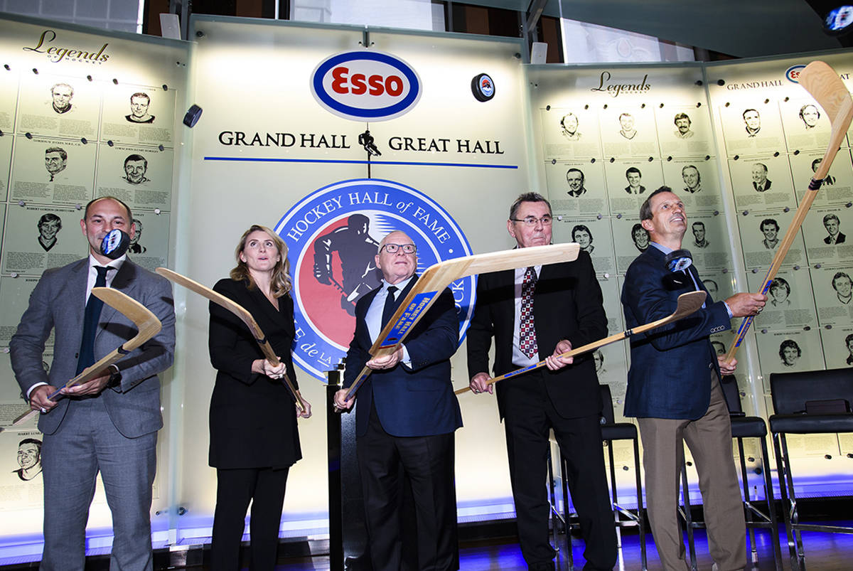 Hockey Hall of Fame inductees Sergei Zubov, (left to right), Hayley Wickenheiser, Jim Rutherford, Vaclav Nedomansky and Guy Carbonneau flip pucks in the air during a ceremony in Toronto on Friday, November 15, 2019. THE CANADIAN PRESS/Nathan Denette