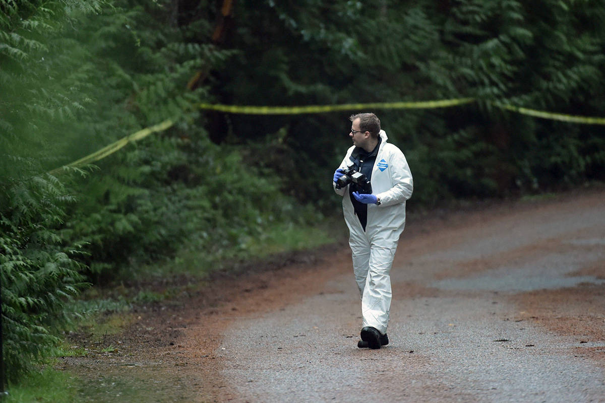An investigator takes photos near the scene of a small plane crash on Gabriola Island, B.C., Wednesday, Dec. 11, 2019. THE CANADIAN PRESS/Jonathan Hayward