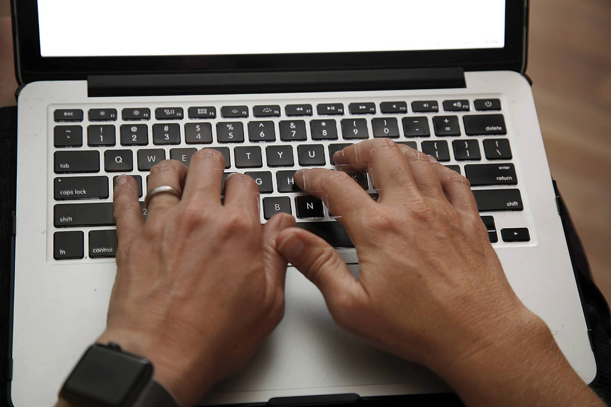 A person works on a laptop in North Andover, Mass., June 19, 2017 file photo. An annual review of how well the government interacts with Canadians applying or managing federal benefits suggests more people would turn to online channels, but only if there was a human around to help them out. THE CANADIAN PRESS/AP/Elise Amendola
