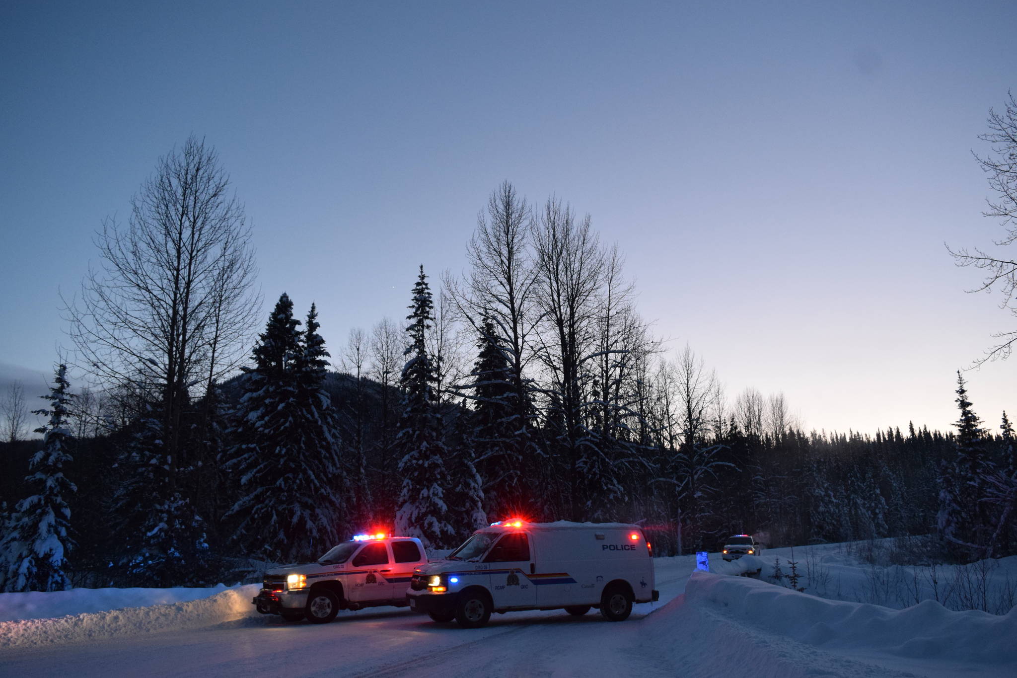RCMP vehicles pictured at the 27-kilometre mark of Morice West Forest Service Road. The RCMP has said they have set up the check point to assure safety and mitigate concerns surrounding a number of hazardous items found in close proximity to a number of felled logs further down the road. (Trevor Hewitt photo)