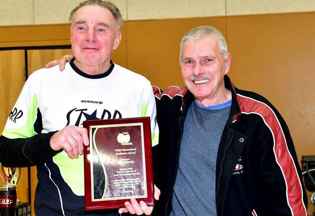 Bruce Hawkes, left, is presented a plaque commemorating his 200th consecutive Island Series race by Bob Reid, high performance director of the Harriers Pioneer 8K. (Joseph Camilleri - Prairie Inn Harriers)