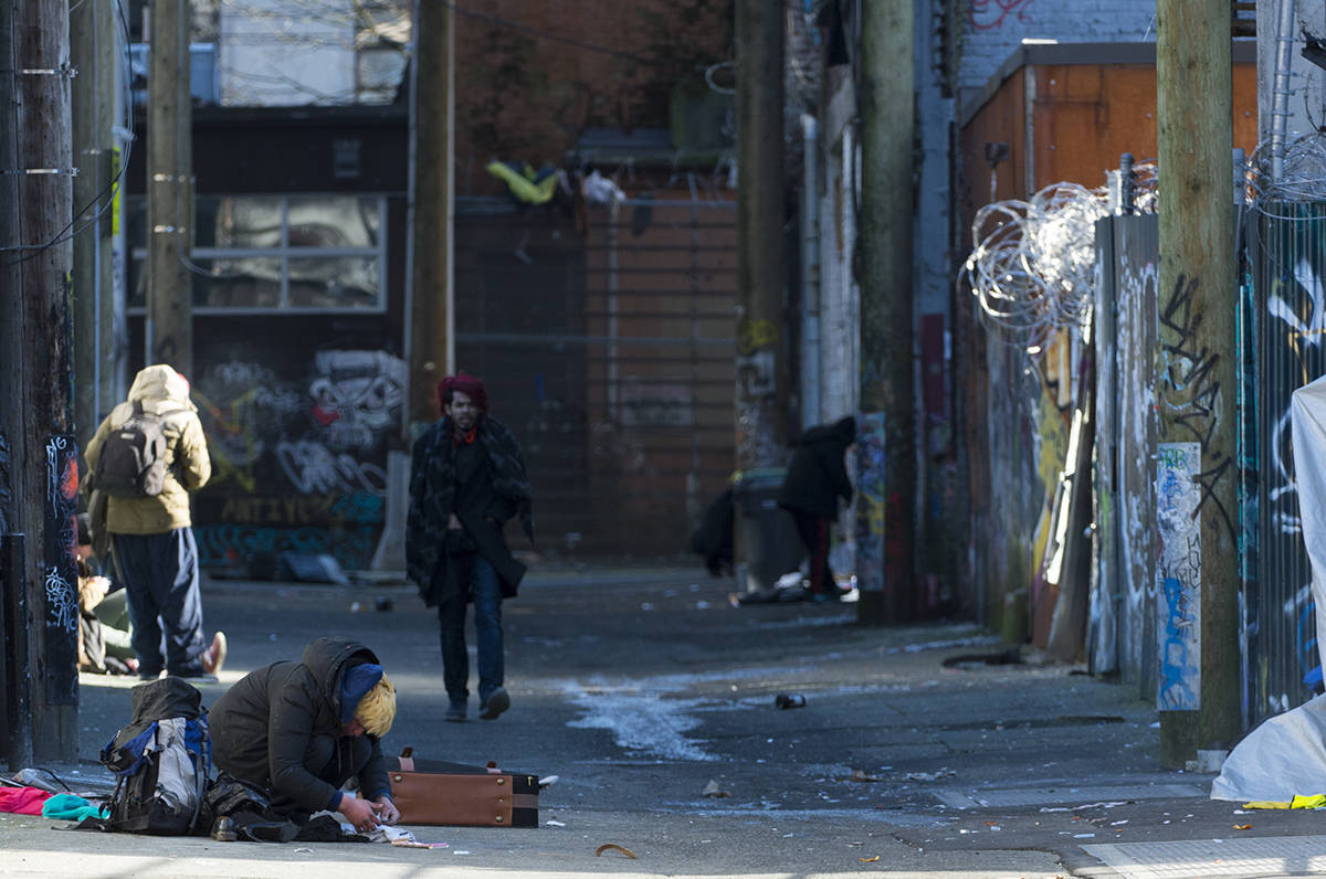 People are seen in an alleyway in Vancouver’s Downtown Eastside, Wednesday, Feb. 6, 2019. British Columbia’s chief coroner is to release statistics for illicit drug overdose deaths in 2018 on Thursday. THE CANADIAN PRESS/Jonathan Hayward