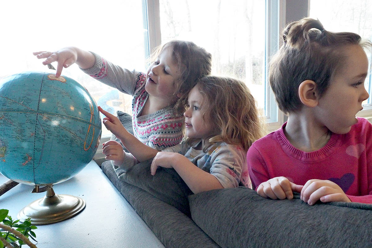 Sullivan Waugh, left, Blake Reimer and Lexi Brule check out places around the planet during play time at Nanaimo Innovation Academy. The facility has received funding to create new childcare spaces that the province says could give parents the chance to return to work or pursue education or other opportunities. See story page A18. (Chris Bush/News Bulletin)