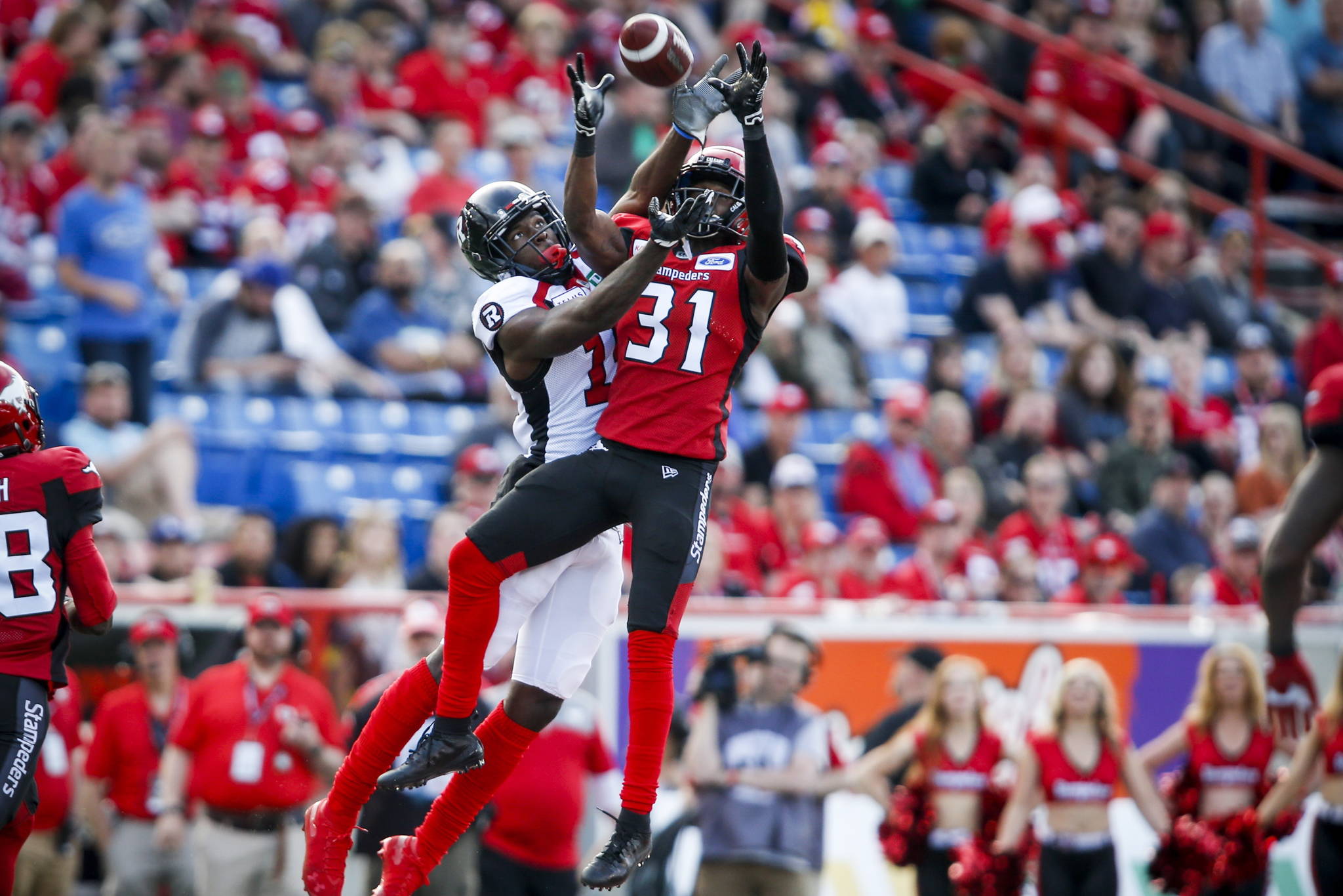 Ottawa Redblacks’ Dominique Rhymes, left, looks on as Calgary Stampeders’ Tre Roberson, catches a pass meant for him during first half CFL football action in Calgary, Saturday, June 15, 2019. The B.C. Lions have signed free-agent wide receiver Rhymes to a one-year contract.THE CANADIAN PRESS/Jeff McIntosh