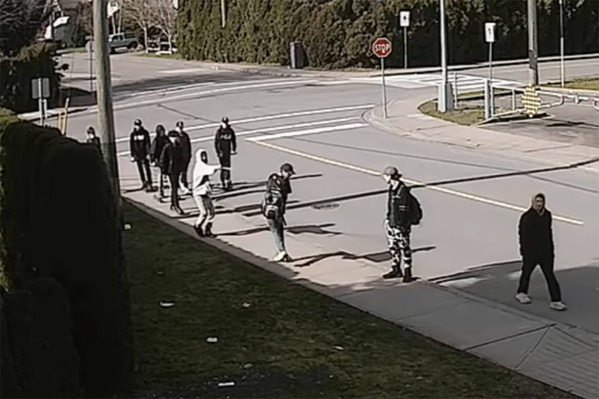 A screenshot of a home security video showing a student firing bear spray at another student on Reece Avenue next to Chilliwack secondary school on March 4, 2020. (YouTube)